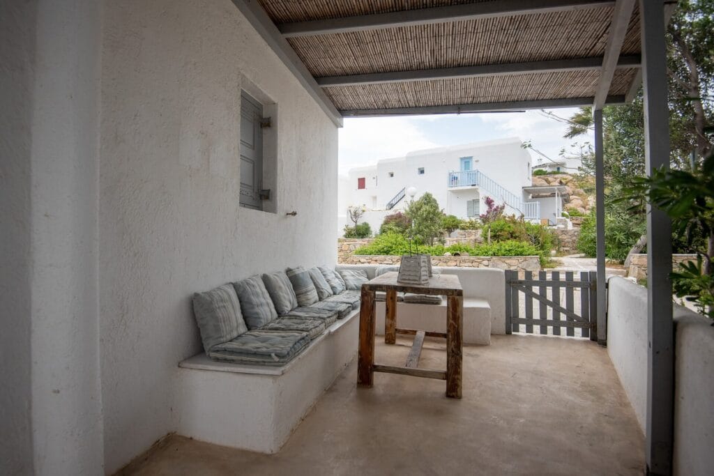 Covered terrace with built-in seating and views towards the Mykonian landscape